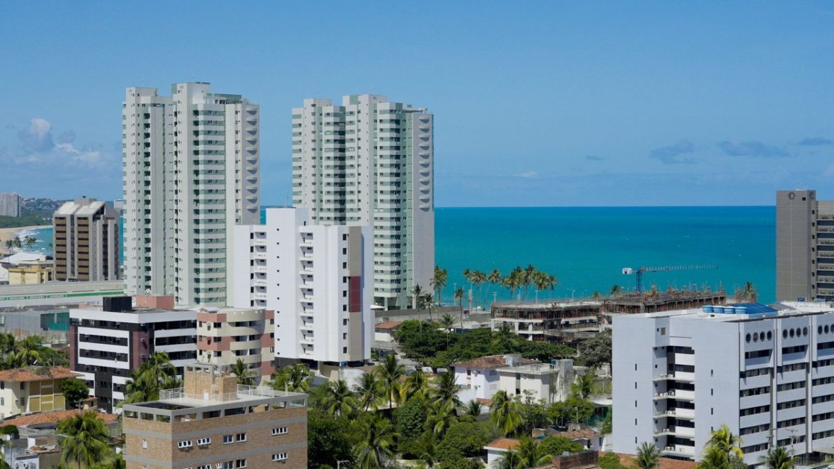 Vista de edifícios de Maceió ao longo da faixa litorânea, sob céu claro.