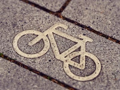 Sinalização de ciclovia com símbolo de bicicleta em uma via urbana.