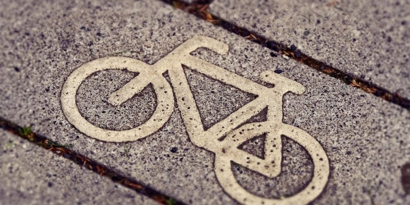 Sinalização de ciclovia com símbolo de bicicleta em uma via urbana.